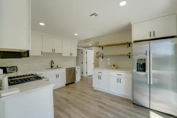 a kitchen with white cabinets and stainless steel appliances