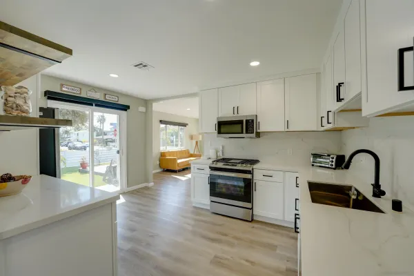 a kitchen with stainless steel appliances a stove a sink a microwave a refrigerator and cabinets