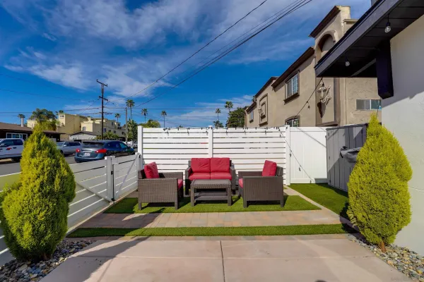 a view of a patio with couches and a table and chairs with potted plants