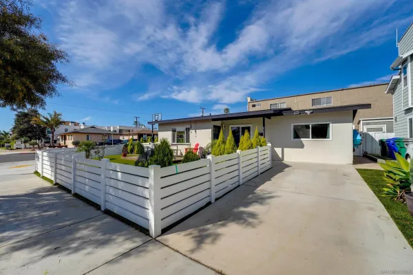 a view of a house with wooden deck and furniture