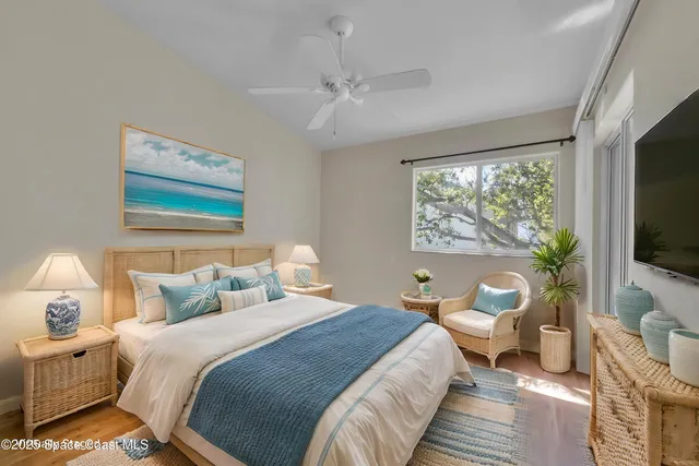 a spacious bedroom with a bed and a flat screen tv