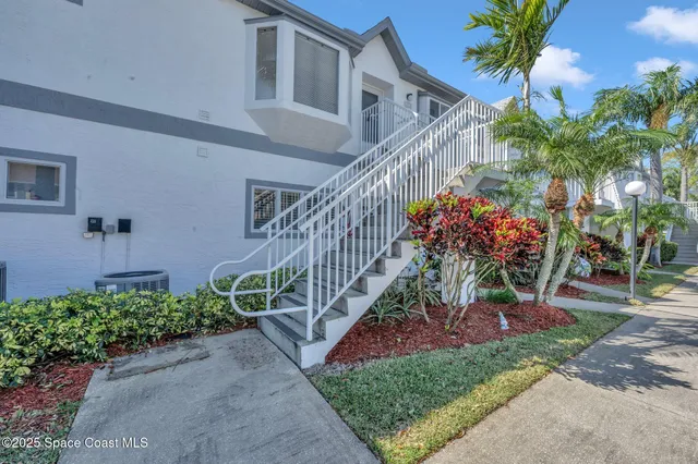 a front view of a house with a yard and potted plants