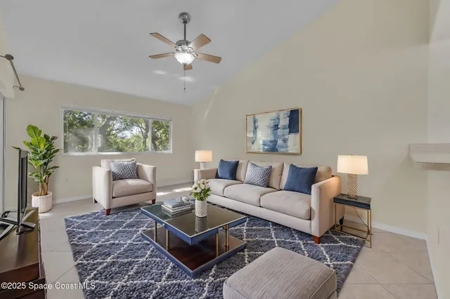 a living room with furniture a chandelier and a rug