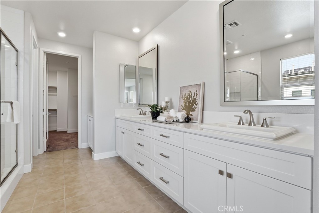 182 Scale Irvine, CA 92618 - Photo 31 of 61 Double sinks, dual mirrors, white shaker cabinetry, quartz counters, and a walk in closet straight ahead. Morning routines just got a serious upgrade.