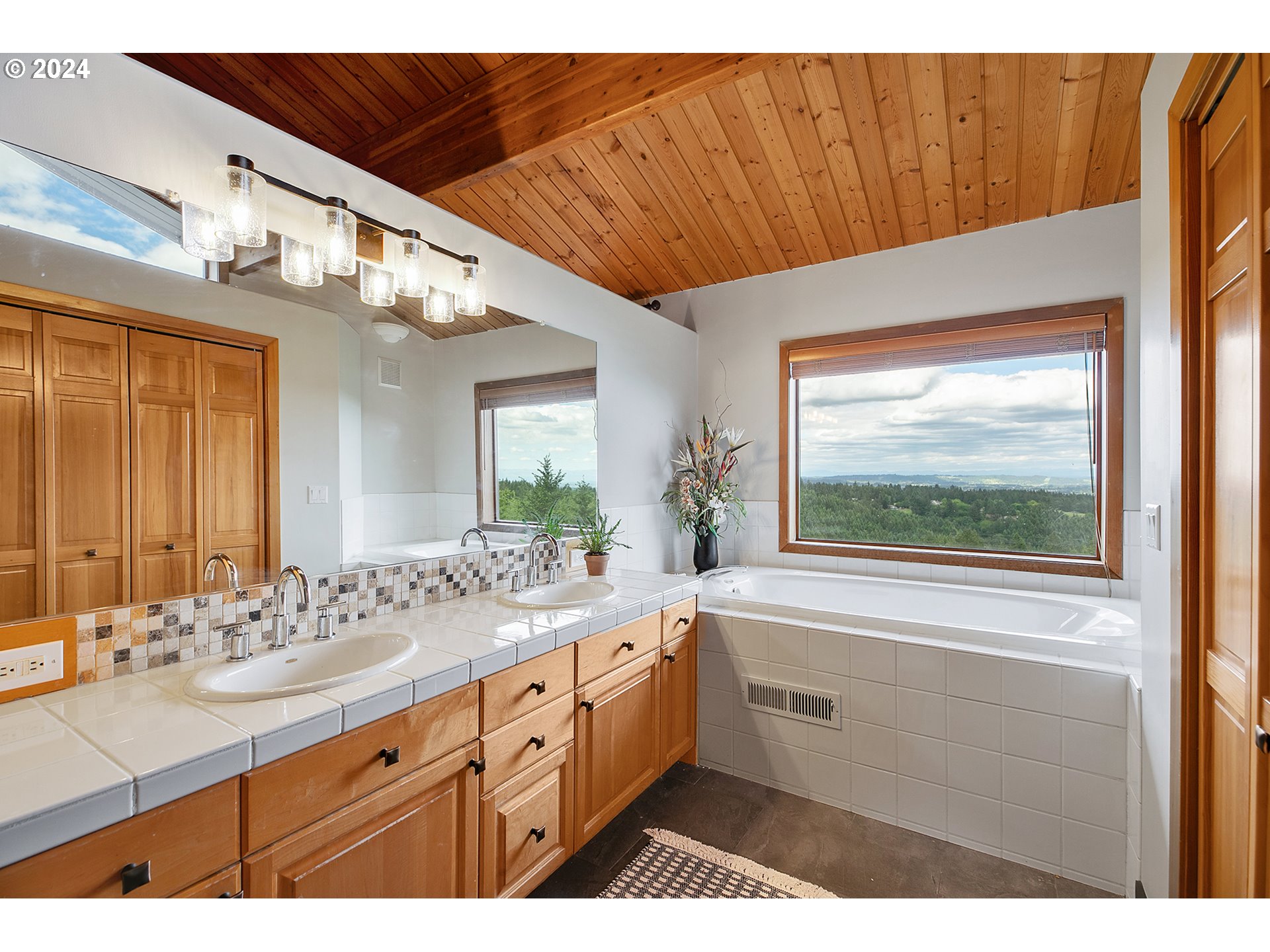 28900 Southwest Heater Road Sherwood, OR 97140 - Photo 25 of 48 a bathroom with a sink a large mirror and a bathtub next to a window
