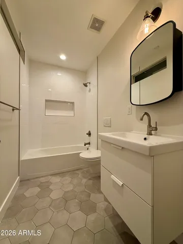 a bathroom with a double vanity sink mirror and bathtub