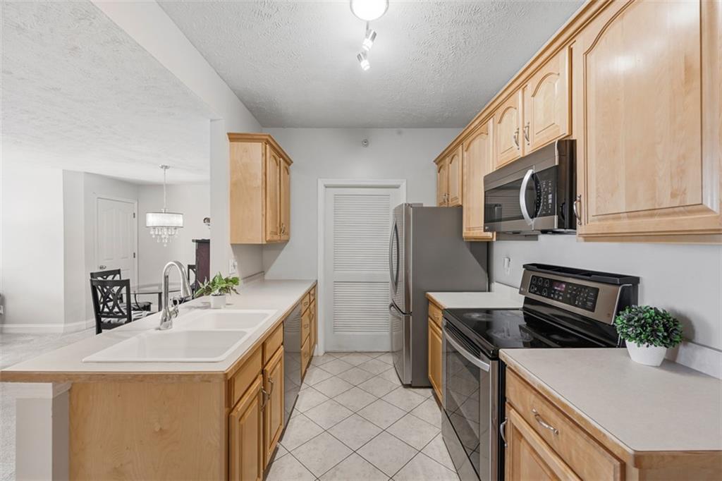 217 Adams Pointe Boulevard, Unit 11 Mars, PA 16046 - Photo 11 of 27 a kitchen with stainless steel appliances a sink a stove a microwave a sink a refrigerator and cabinets
