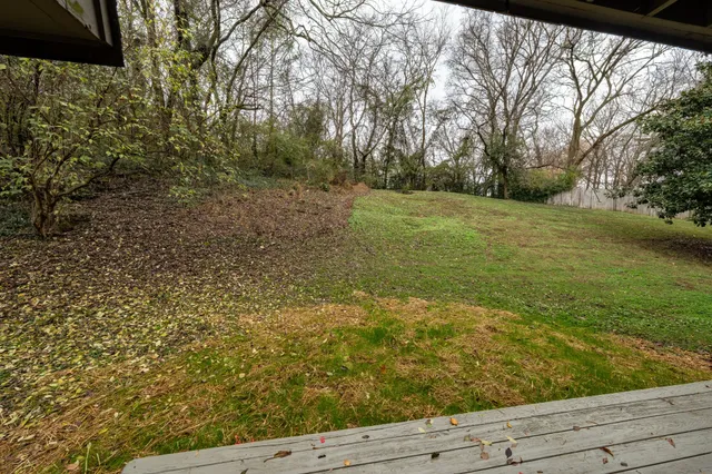 a view of a yard with wooden fence