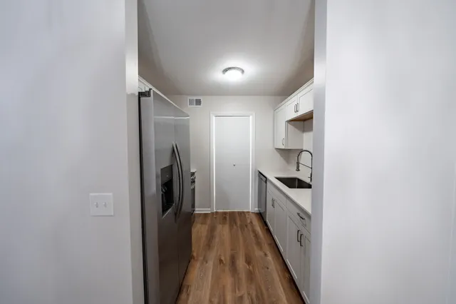 a view of a kitchen with a sink and refrigerator