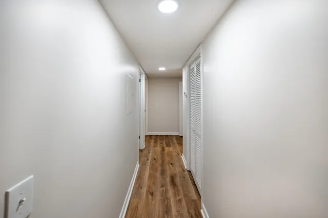 a view of a hallway with wooden floor
