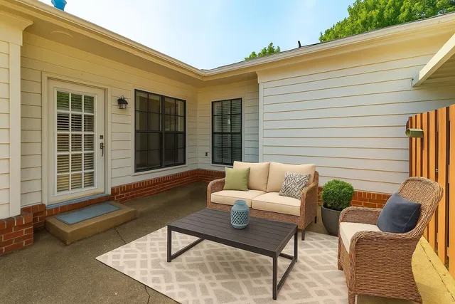 a view of a patio with couches chairs and wooden floor