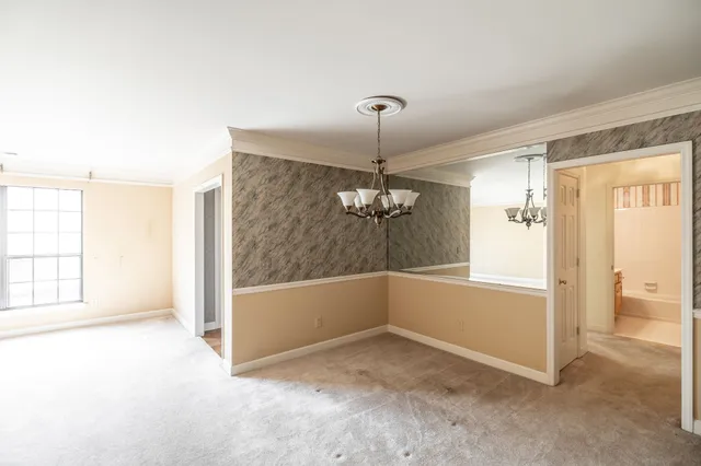 an empty room with chandelier and windows