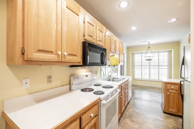 a kitchen with a sink a stove and a microwave