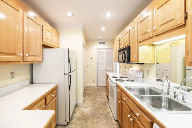 a kitchen that has a sink a refrigerator and a sink