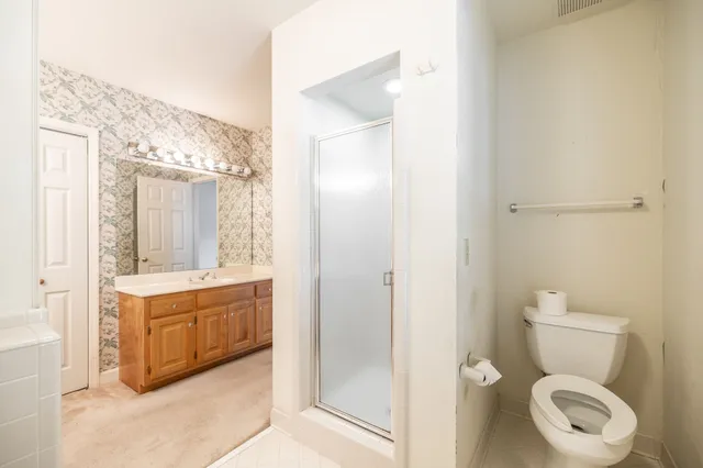 a bathroom with a granite countertop toilet a sink and a mirror