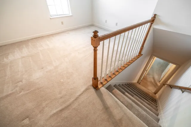 a view of staircase with white walls and a window