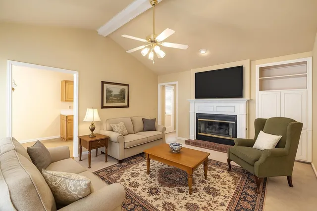 a living room with furniture a fireplace and a flat screen tv