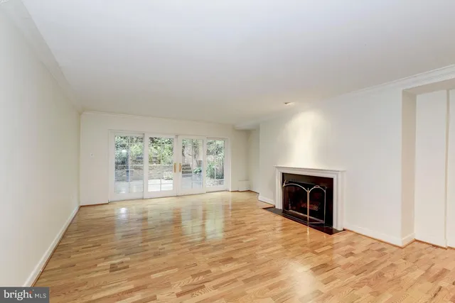 an empty room with floor to ceiling window and fireplace