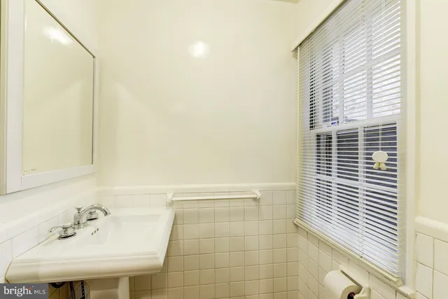 a bathroom with a sink a bathtub and next to a window