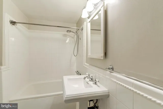 a bathroom with a sink mirror and a shower