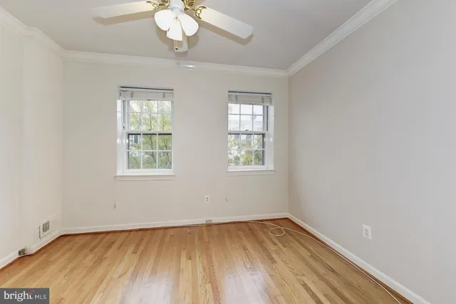 an empty room with a window and wooden floor