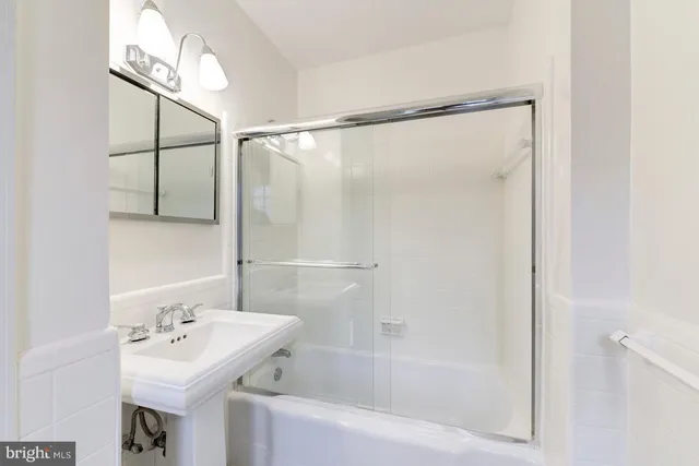a bathroom with a sink mirror and a bathtub