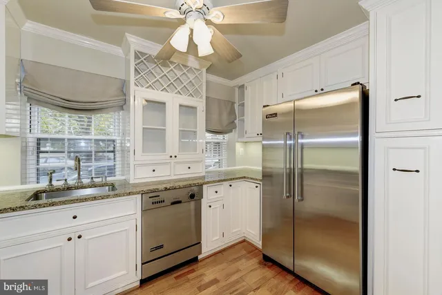 a kitchen with a refrigerator and countertop white cabinets