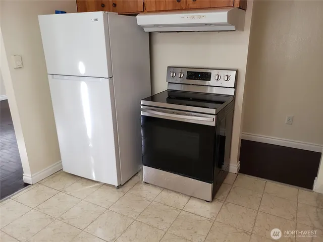 a stove top oven sitting inside of a kitchen