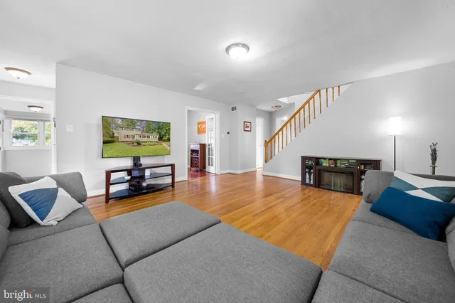 a living room with furniture floor to ceiling window and wooden floor