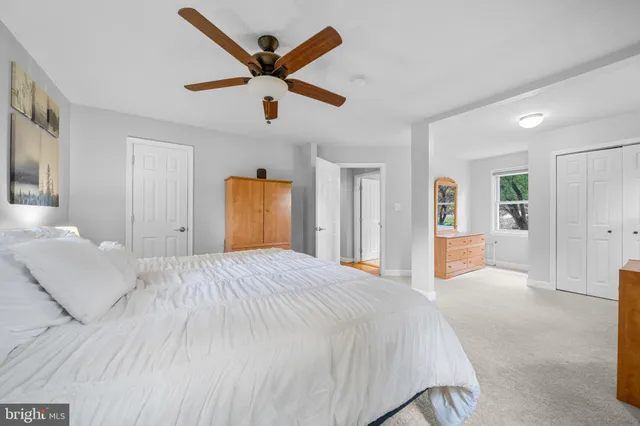 a spacious bedroom with a large bed and a chandelier