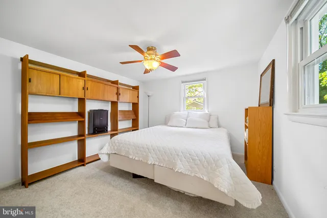 a bedroom with a large bed a chandelier and dresser