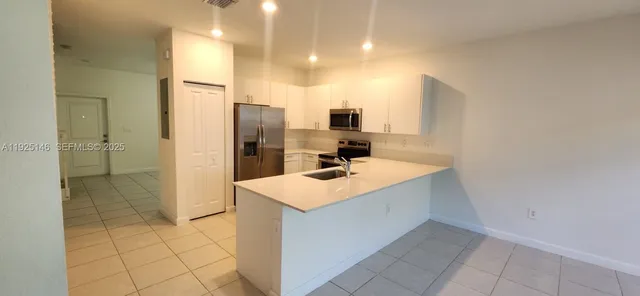 a kitchen with a sink a refrigerator and cabinets
