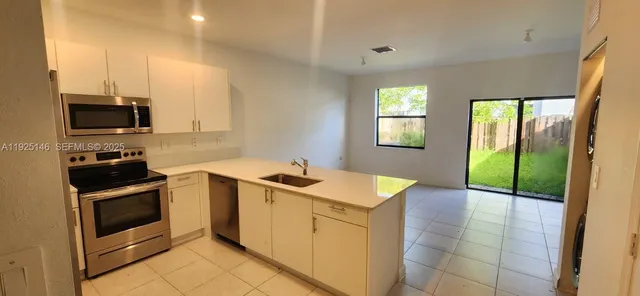 a kitchen that has a sink and a stove top oven