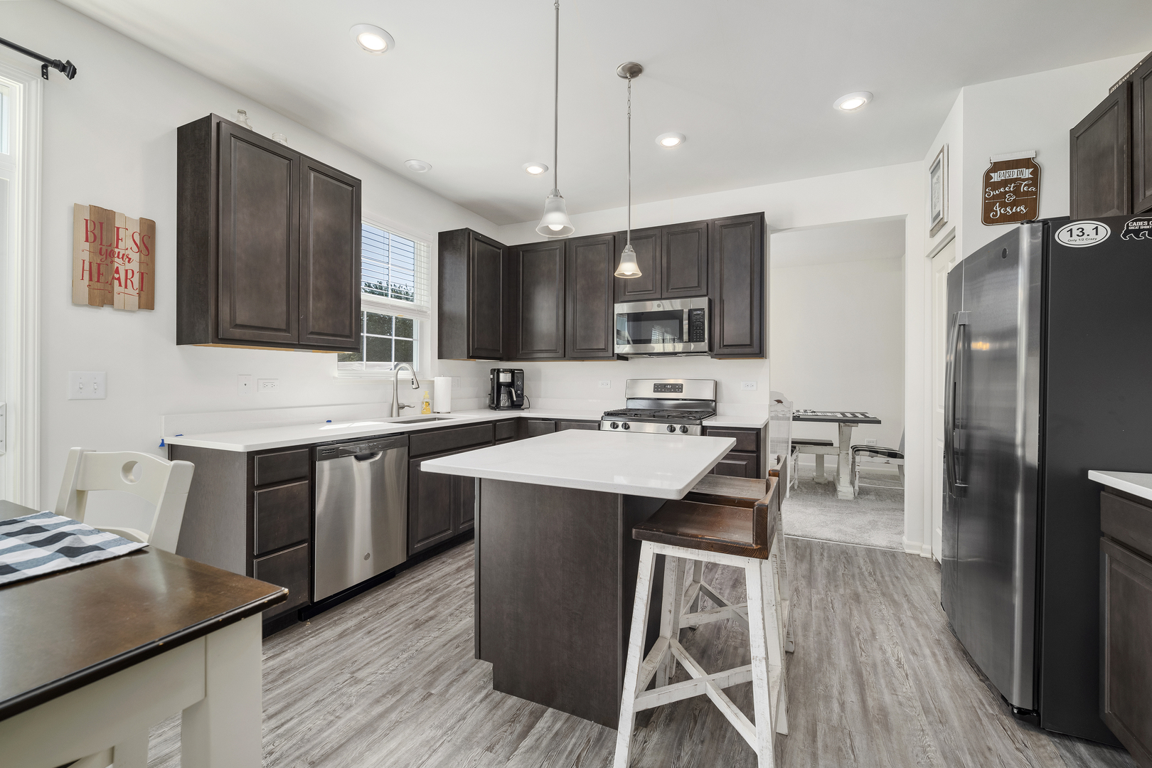 704 Long Ridge Trail Minooka, IL 60447 - Photo 12 of 33 a kitchen with stainless steel appliances kitchen island granite countertop a sink stove and refrigerator