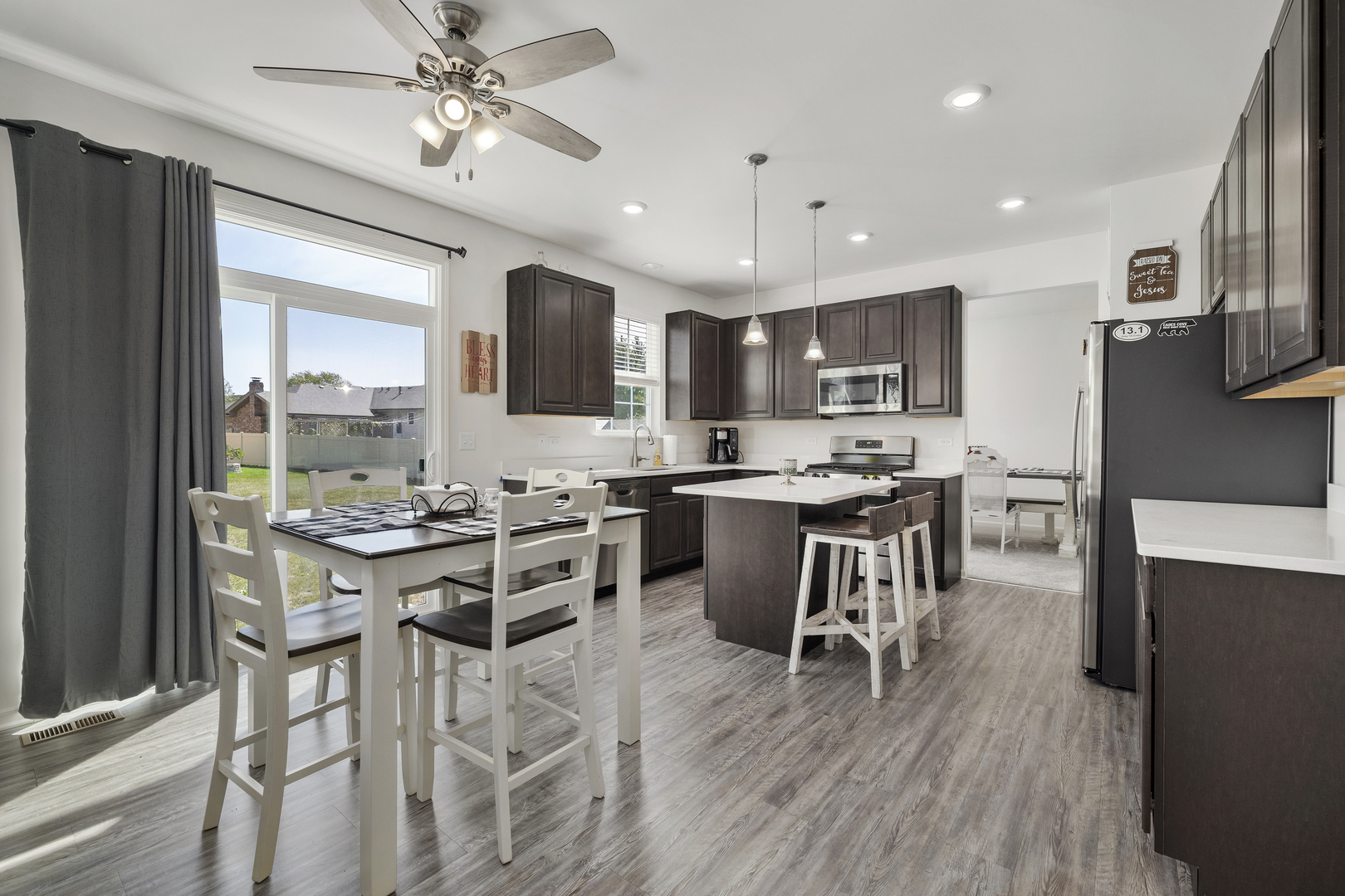 704 Long Ridge Trail Minooka, IL 60447 - Photo 17 of 33 a kitchen with stainless steel appliances kitchen island granite countertop a stove top oven a sink a dining table and chairs