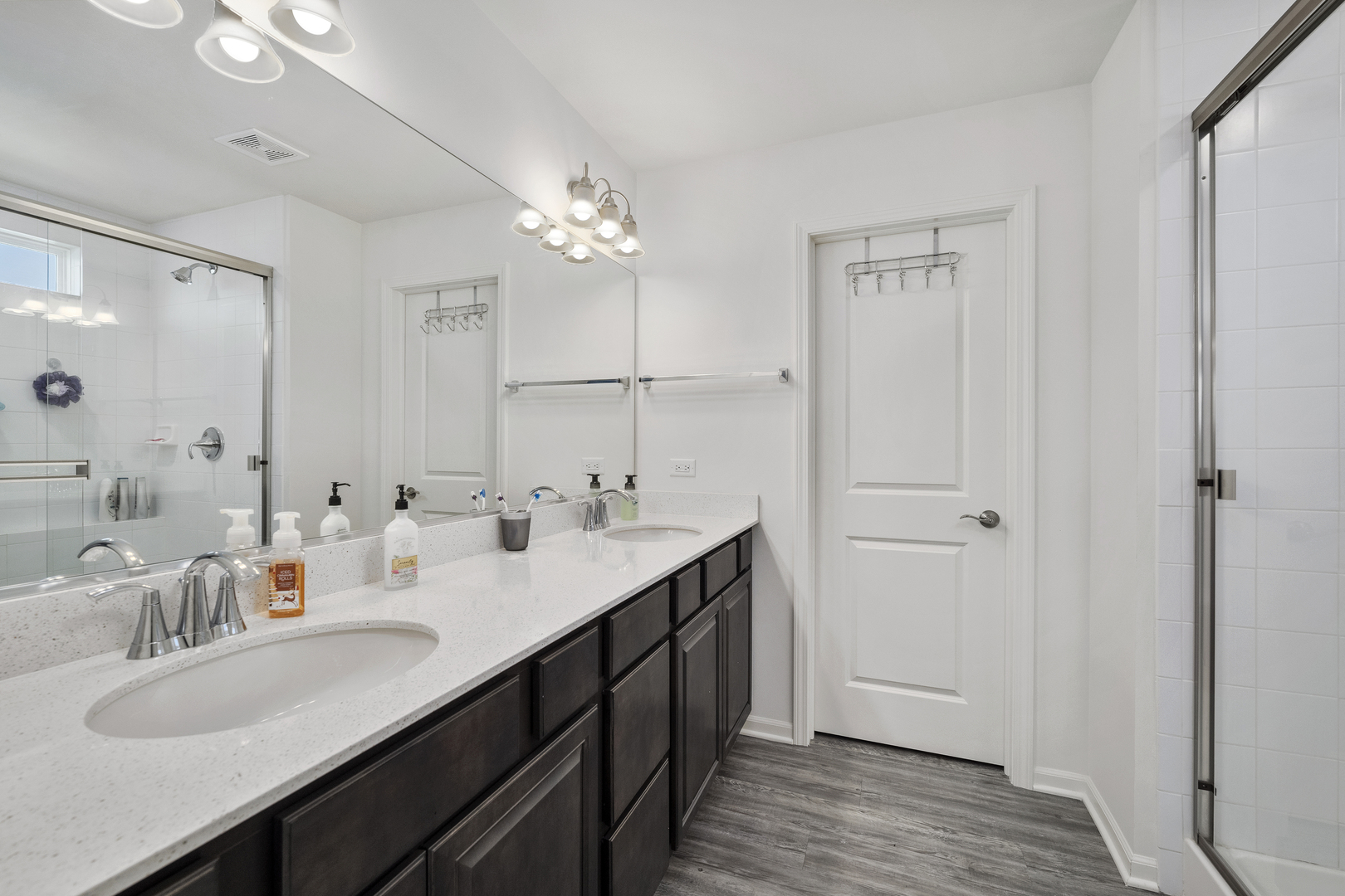 704 Long Ridge Trail Minooka, IL 60447 - Photo 22 of 33 a en suite bathroom with a double vanity sink a mirror and a shower