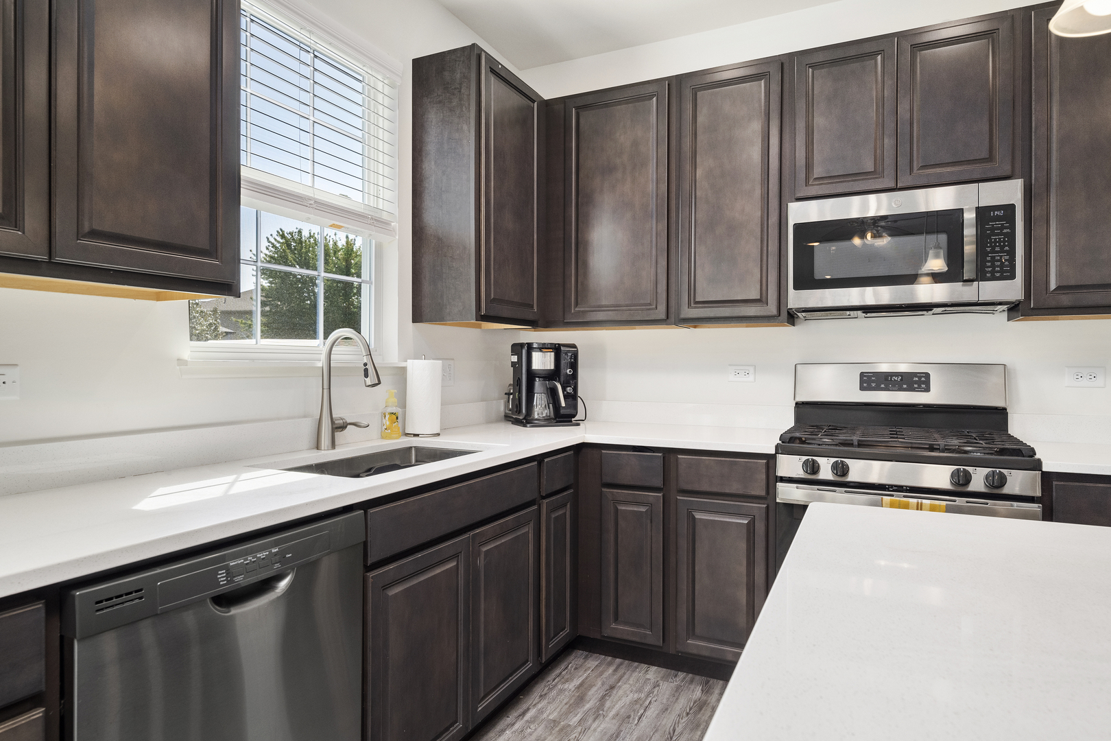 704 Long Ridge Trail Minooka, IL 60447 - Photo 9 of 33 a kitchen with a sink stove and microwave