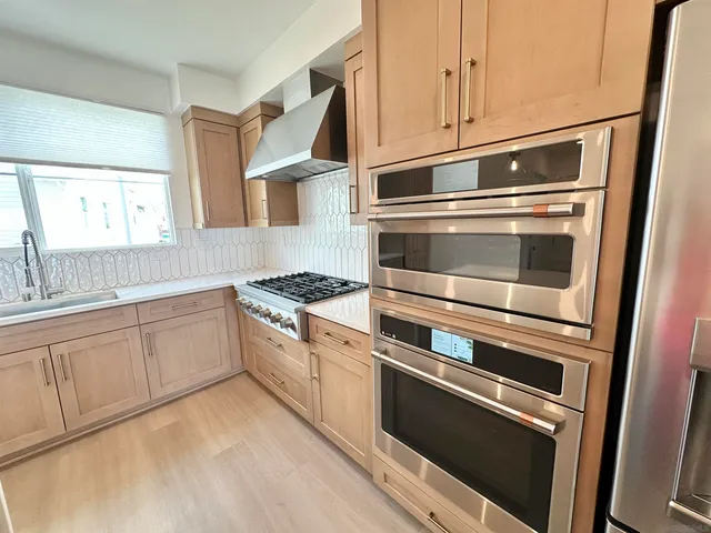 a kitchen with granite countertop stainless steel appliances and white cabinets
