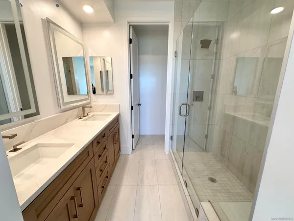 a spacious bathroom with a shower sink and mirror