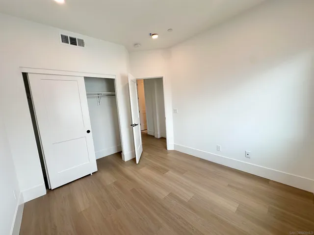 an empty room with wooden floor and entrance