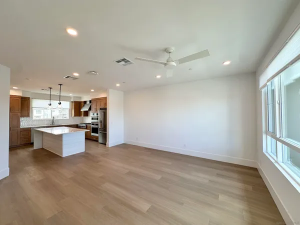 a large kitchen with stainless steel appliances granite countertop a large counter top a stove and a sink