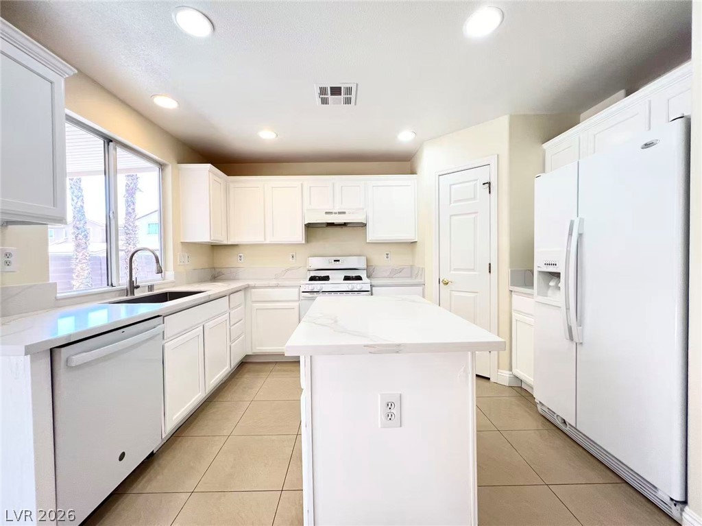 9891 Ridge Hill Avenue Las Vegas, NV 89147 - Photo 9 of 29 Culinary delights await in this bright kitchen, complete with a center island and generous counter space.