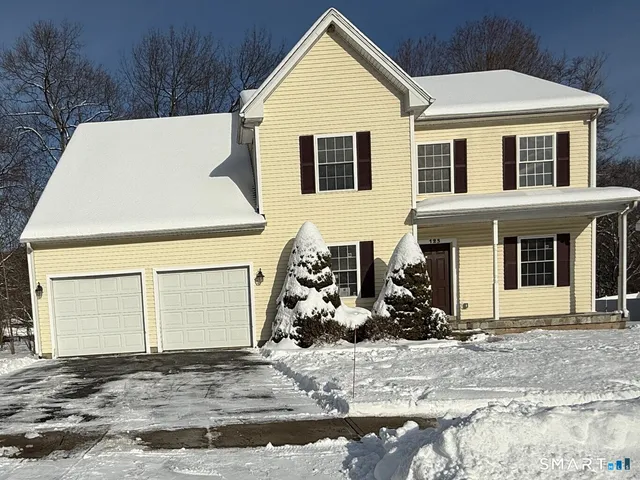 a view of a white house with potted plants in front of it