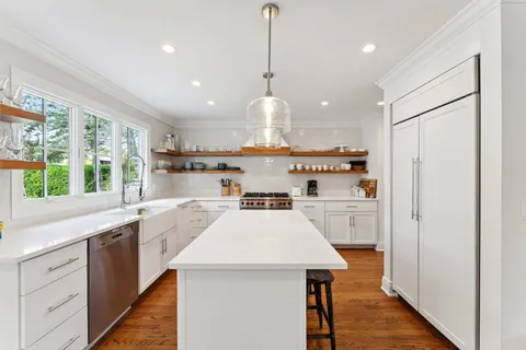 a kitchen with kitchen island a sink appliances and a large window
