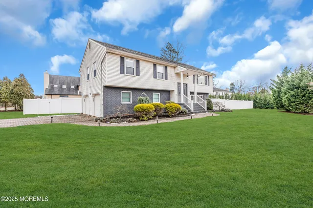 a backyard of a house with table and chairs plants and large tree