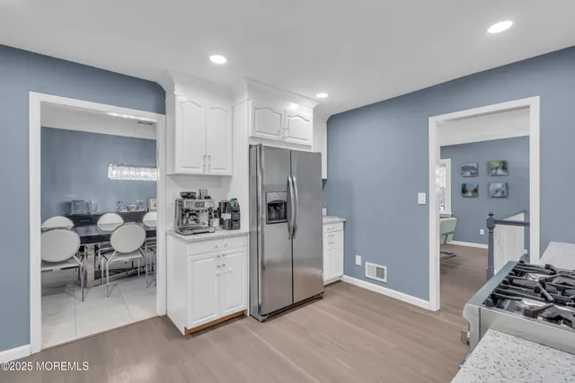 a view of a kitchen with furniture and refrigerator