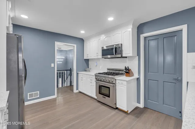 a kitchen with stainless steel appliances a refrigerator a stove top oven a sink and dishwasher