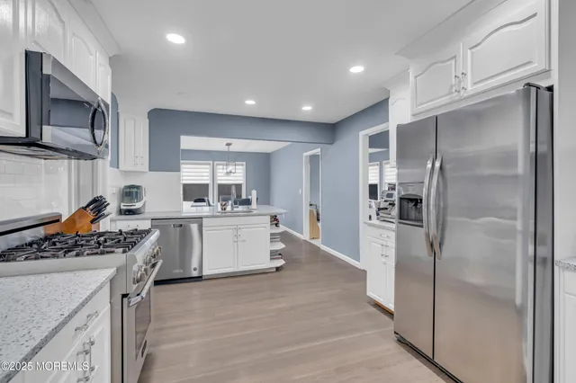 a kitchen with a refrigerator a sink and a stove top oven
