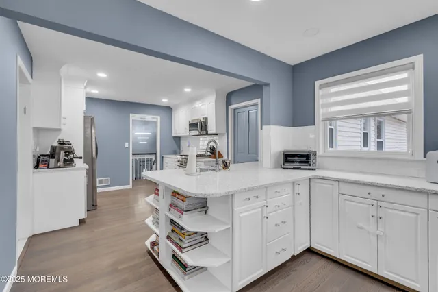 a large white kitchen with cabinets appliances and a sink