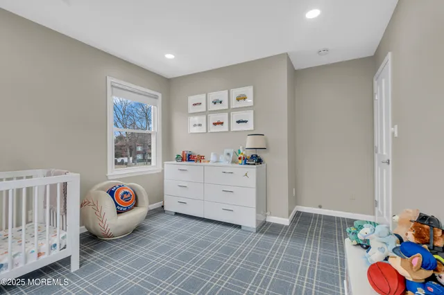 a view of a bedroom with baby crib and toys